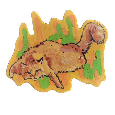 Pancake art of a orange tabby cat named Richard lying flat and stretched out horizontally, with one paw extended forward and the tail curling upward toward the upper right; a round shape, possibly a ball of yarn, appears in the upper right corner. The piece uses bold black outlines over a warm yell…