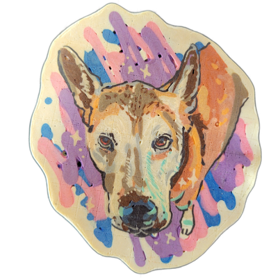 A pancake art portrait of a dog named Maddy, depicted from the shoulders up, facing forward, with alert upright ears, a broad muzzle, and brown eyes accented with small red highlights and surrounded by teal sparkle marks; the background features radiating paint-splatter shapes in violet, pink, indi…