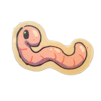 Hermie, a JoP original character depicted as a cartoon worm with a round head, one large dark eye with a small white highlight, and a small curved mouth, with a segmented body that curves into an S-shape and tapers toward the tail end. The pancake art uses bold black outlines, a pink and salmon col…