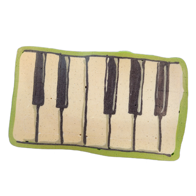 A pancake art rendering of a piano keyboard section, showing white keys and black keys arranged in the standard pattern of groups of two and three black keys across a rectangular shape with rounded corners and a green border.
