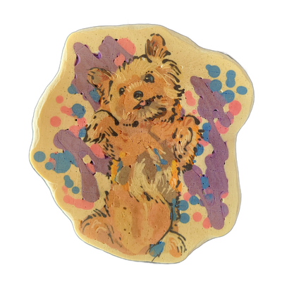 A small, fluffy dog named Lucy sits upright facing forward, rendered in pancake art with warm orange and tan tones for the fur, dark brown fine-line outlines defining facial features, ears, and individual fur strands, and a light cream background field. The composition is surrounded by a scattered…