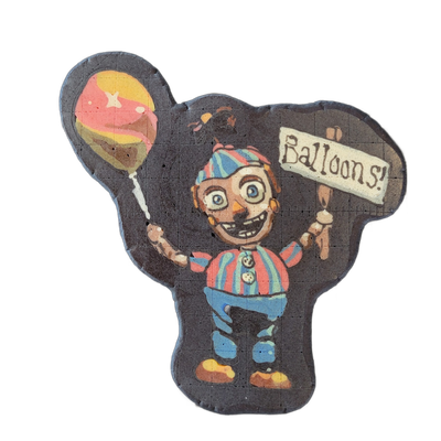 Pancake art depicting Balloon Boy, a cartoon animatronic character wearing a red-and-blue striped shirt, blue pants, brown shoes, and a striped hat, holding a colorful balloon in one hand and a sign reading 'Balloons!' in the other, with an open-mouthed grin and wide circular eyes. Rendered by Dan…