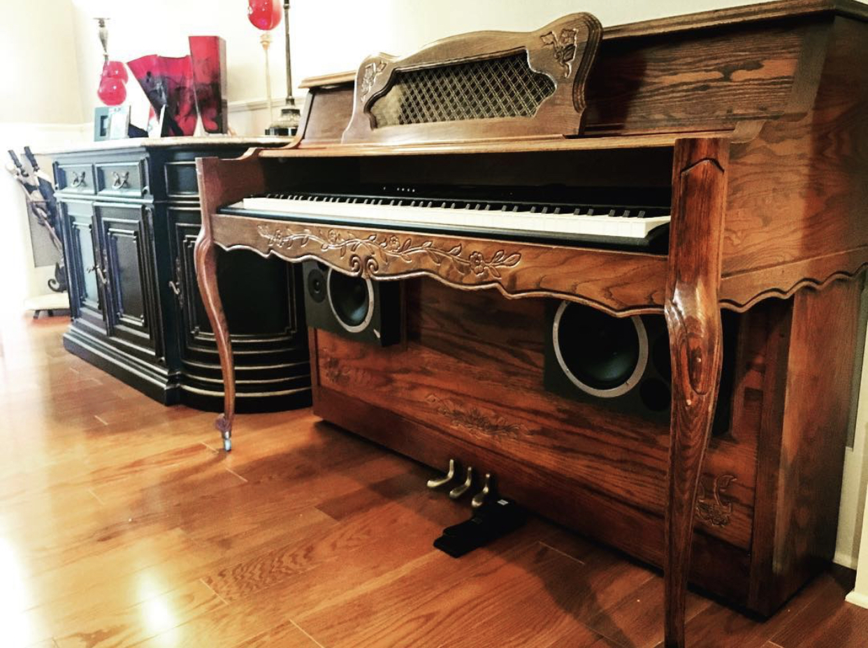 A custom upright piano shell prepared for the home with speakers installed