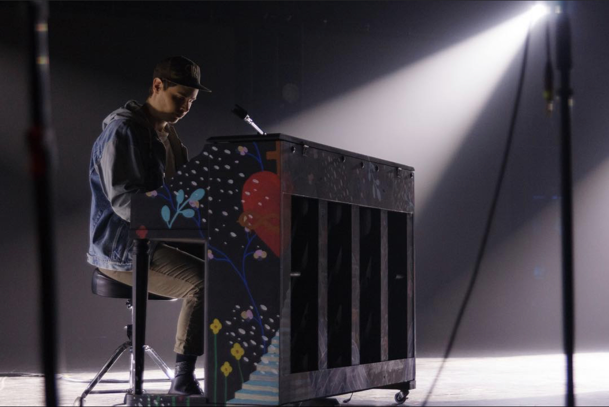 An upright piano shell custom painted for a band on stage for at a live performance