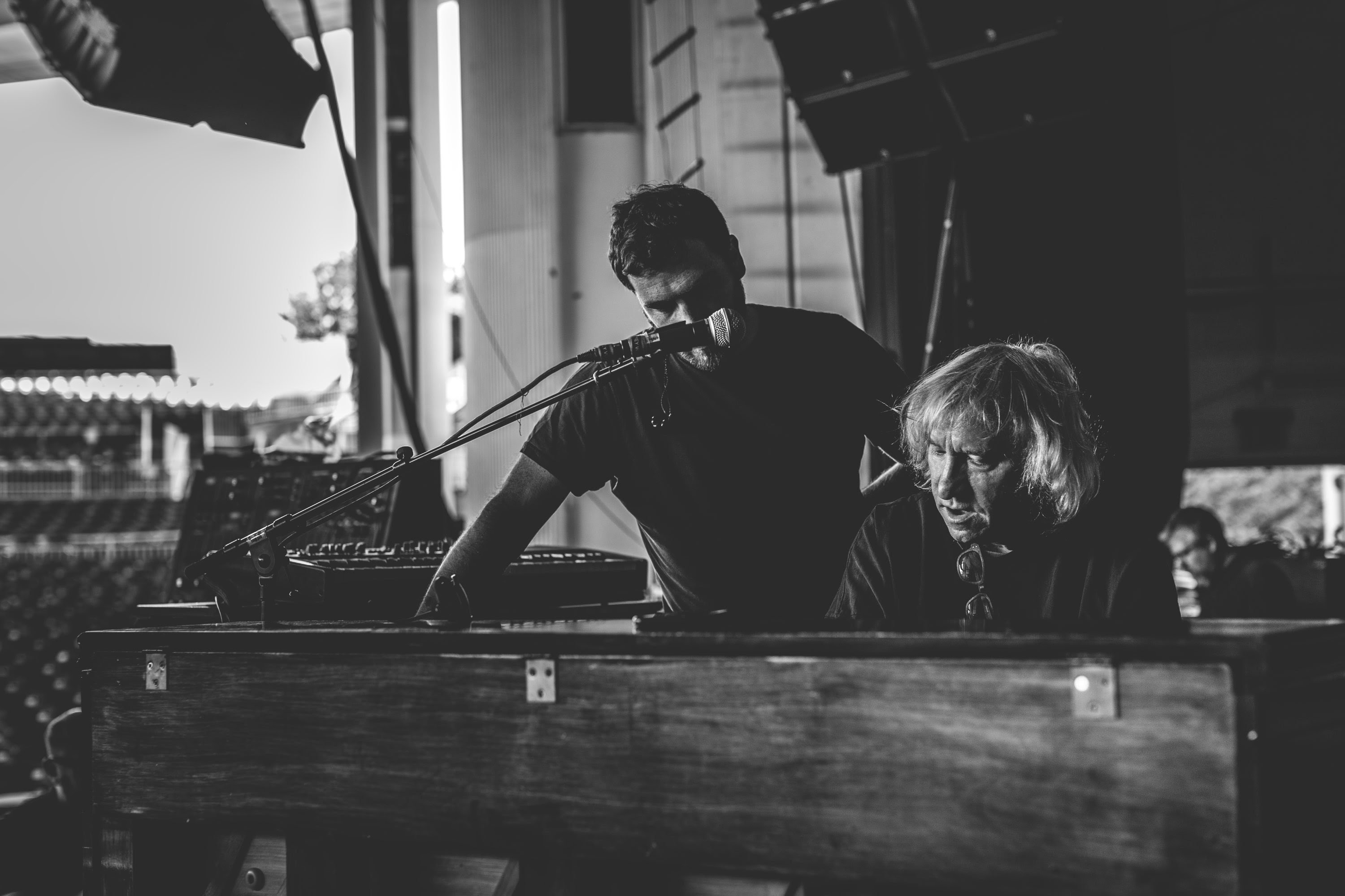 An Upright Piano Shell on a stage with Jimmy Wallace and Joe Walsh