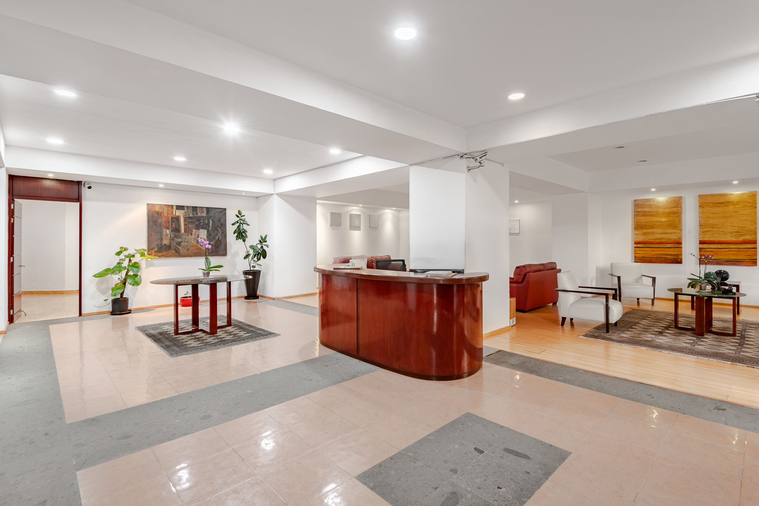 Building lobby with a curved wood desk and seating.