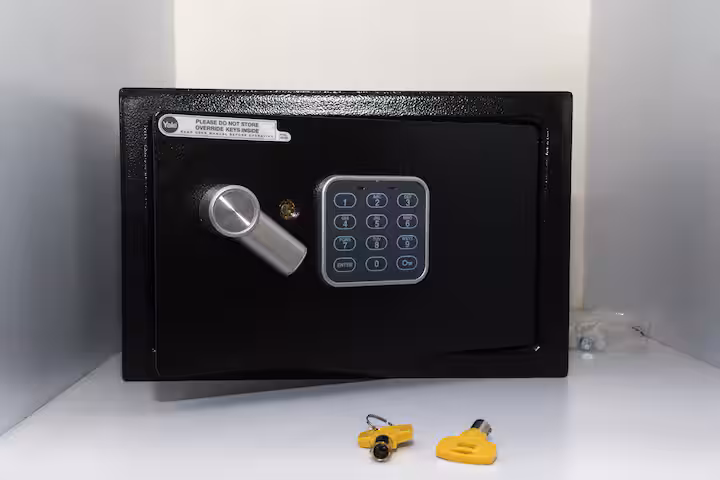 Black safe with a keypad and keys.