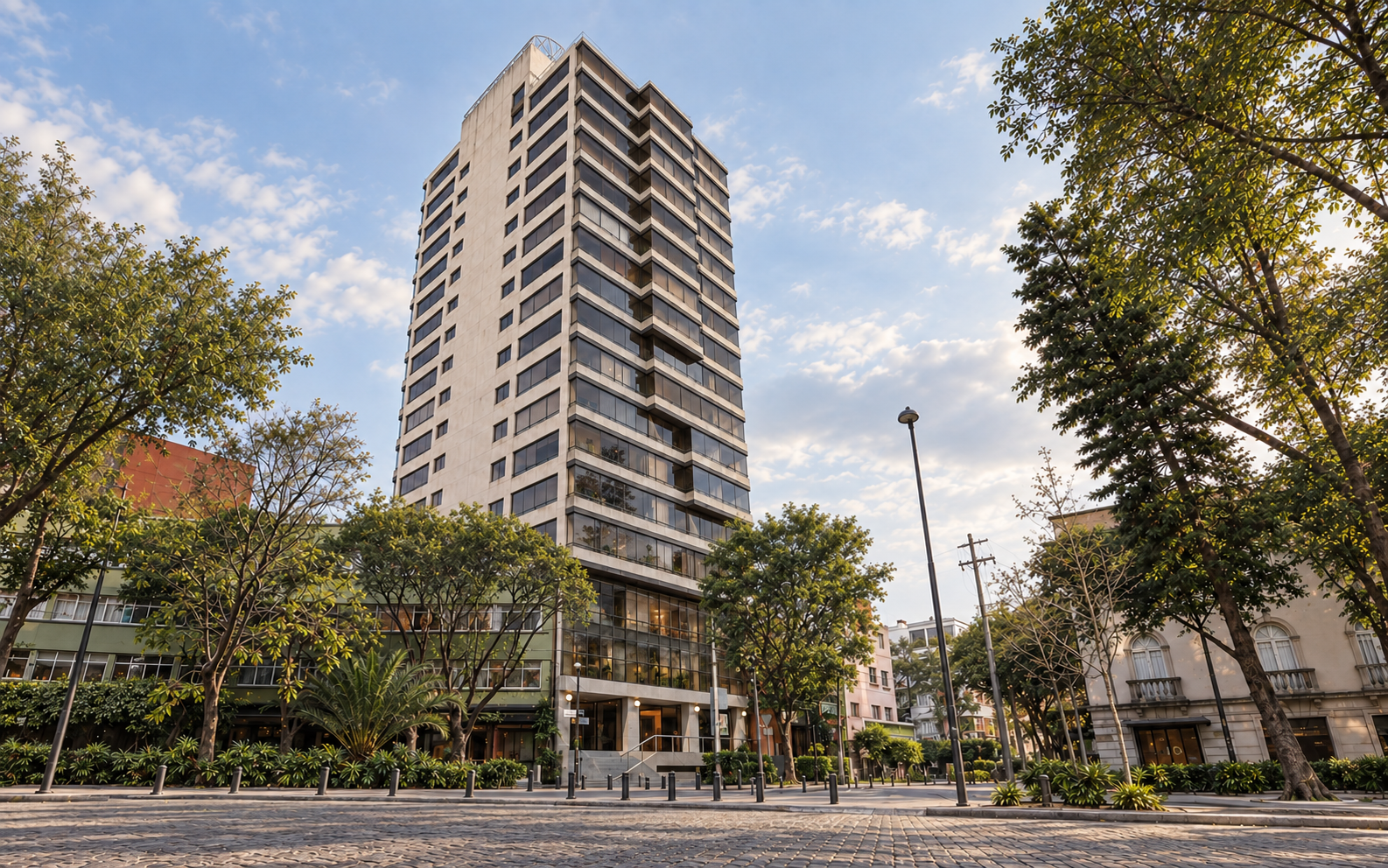 Tall apartment building along a tree-lined street.
