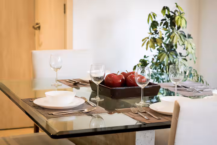 Dining table set with plates and glassware.