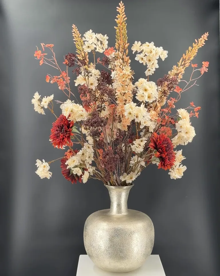 Zijden boeket Marise met crème bloesem, bruine zonnebloemen en zalmkleurige takken in een lichte vaas.