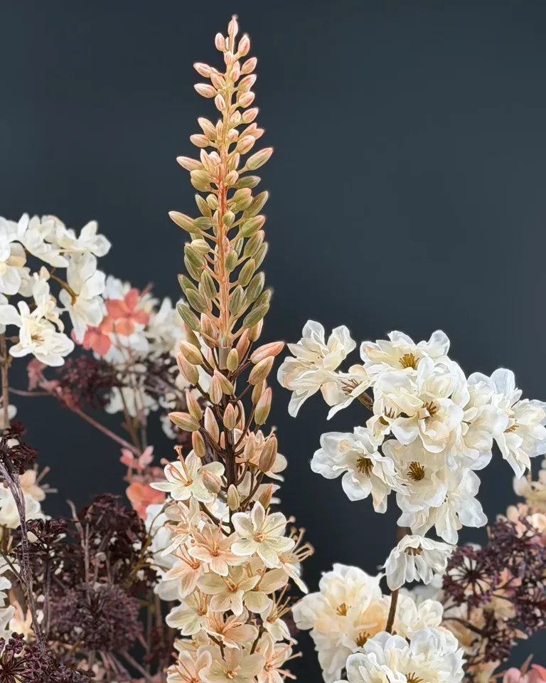 Opgaande crèmekleurige eremurus met lichte bloesem en fijne donkere takjes in boeket Marise.