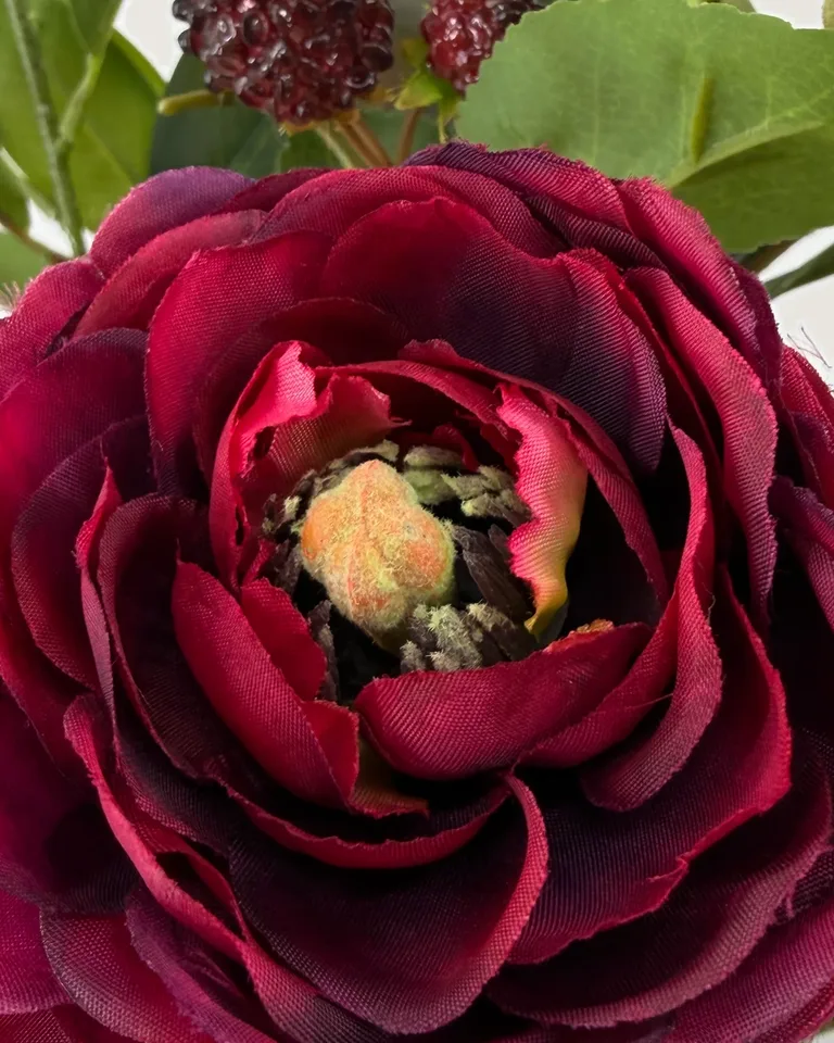 Close-up van een burgundy ranonkel in zijden boeket Rubina