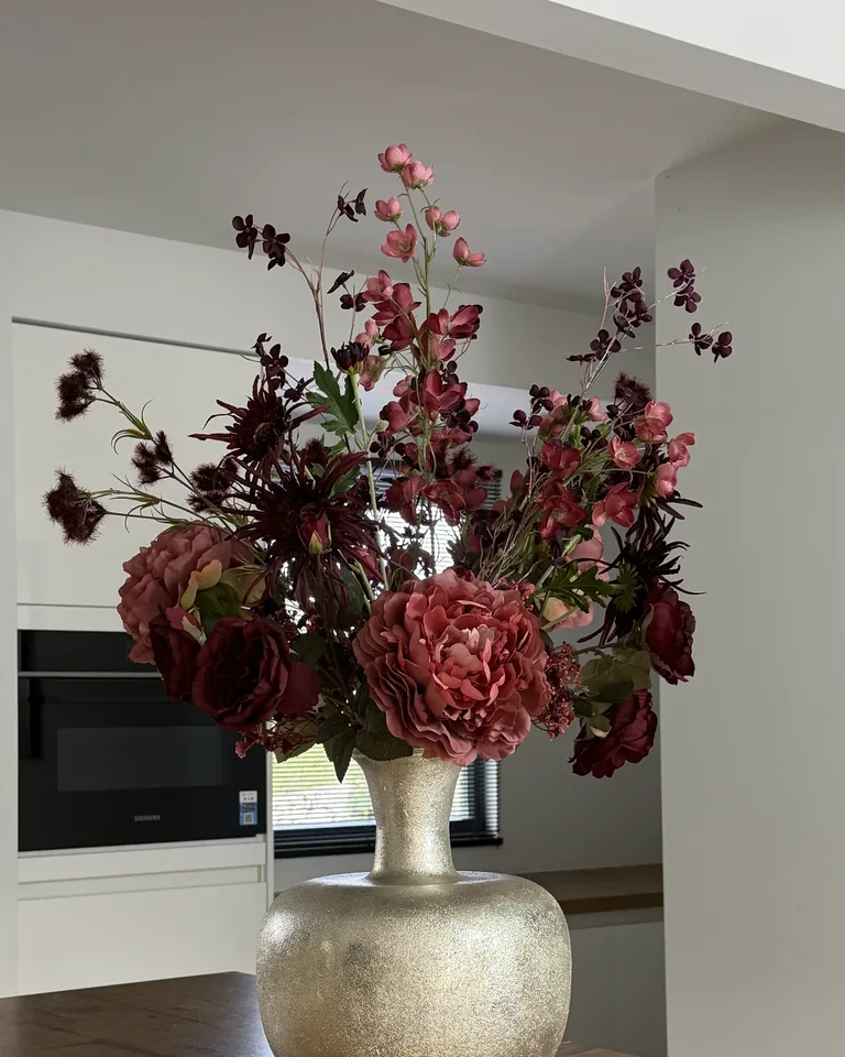 Aurelia, een bordeaux en oudroze veldboeket in een interieur.