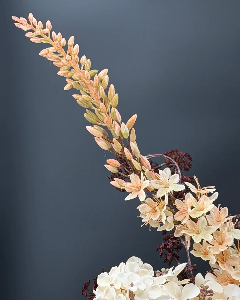 Zachte perzikkleurige bloemtak naast crème hortensia in boeket Cassia