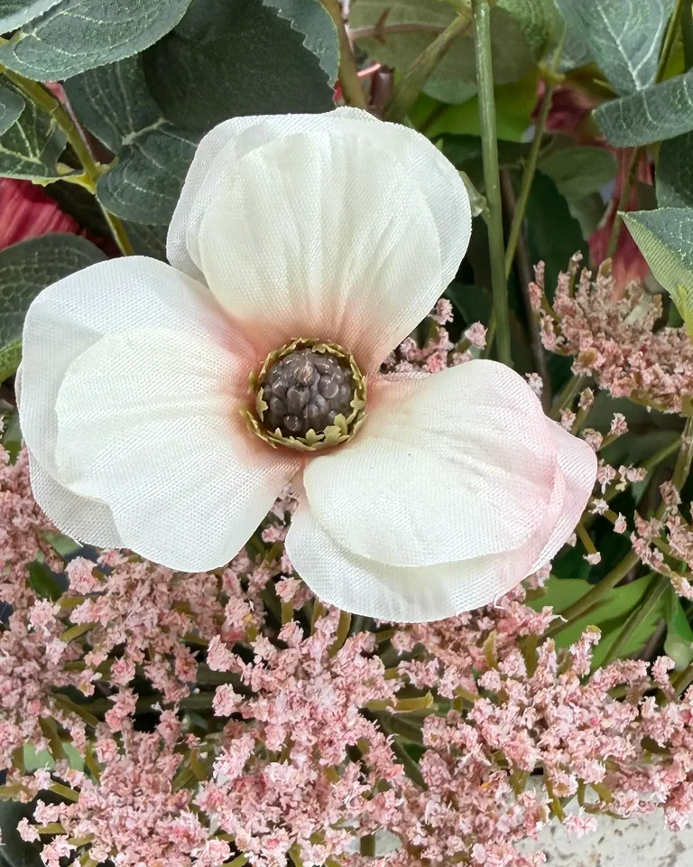 Detail van een wit-roze bloem met donkere kern en fijne roze takjes in Arielle