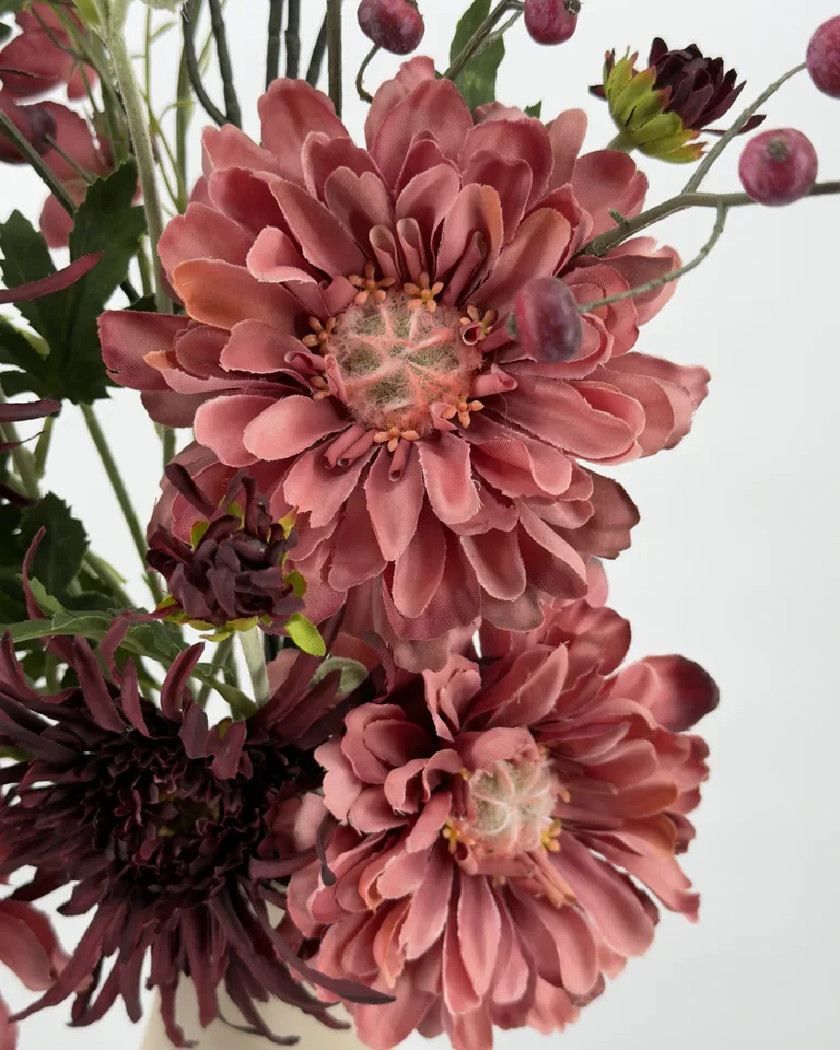 Detail van een grote mauve-koraalroze bloem met donkere bloemen en fijne takken van boeket Liora.