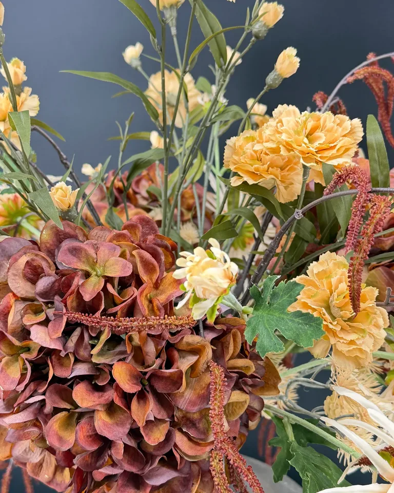 Detail van Carmela met bruine hortensia, lichte bloemen en gebogen corylistakken.