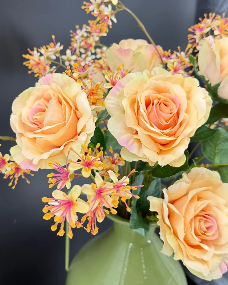 Detailfoto van Rosa boeket met zalmroze rozen en fijne bloemen.