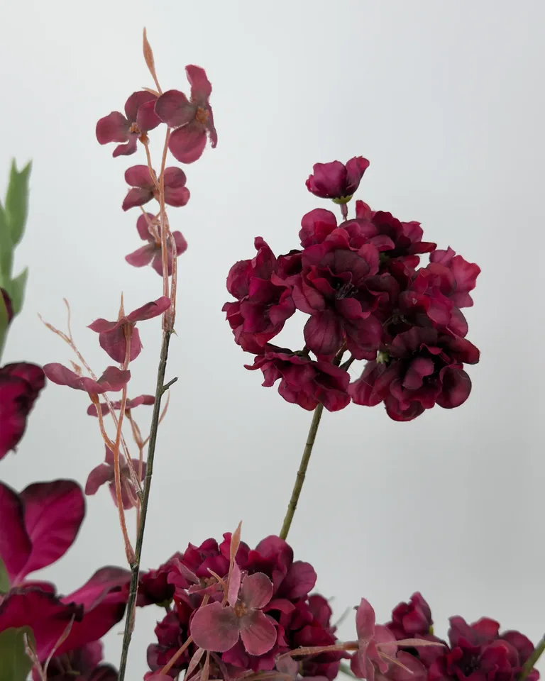 Amora. Fleurig asymmetrisch boeket in burgundy en roze tinten.