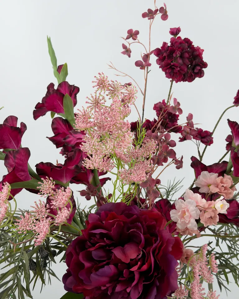 Amora. Fleurig asymmetrisch boeket in burgundy en roze tinten.