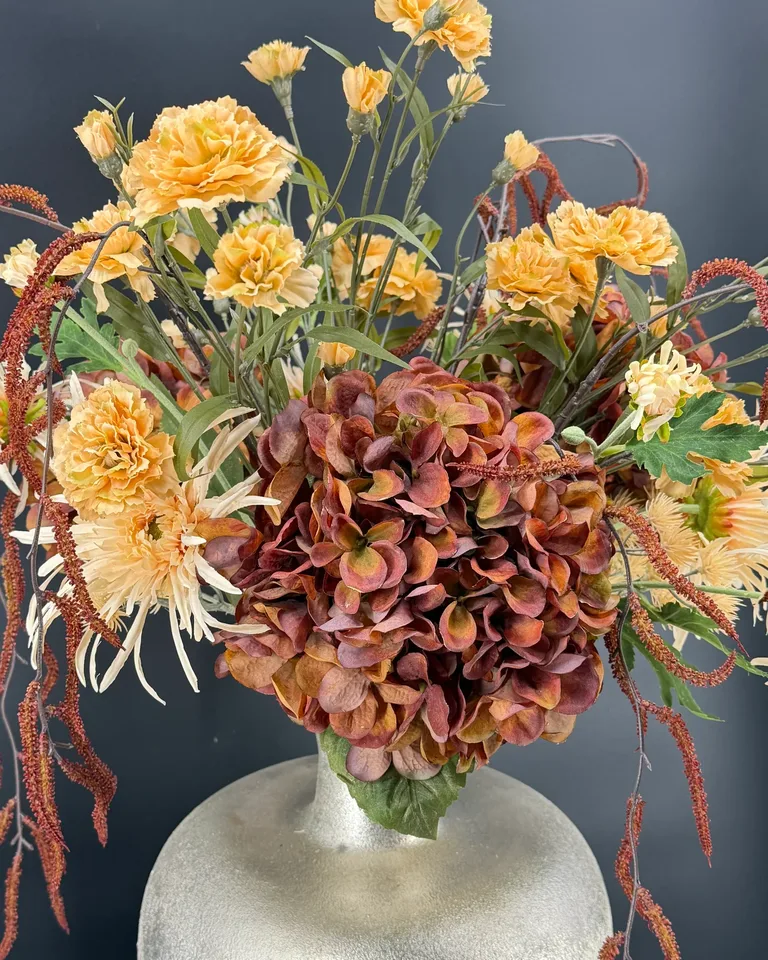 Detail van bruine hortensia met crème achillea, groen blad en bruine corylis-takken in Bruna.