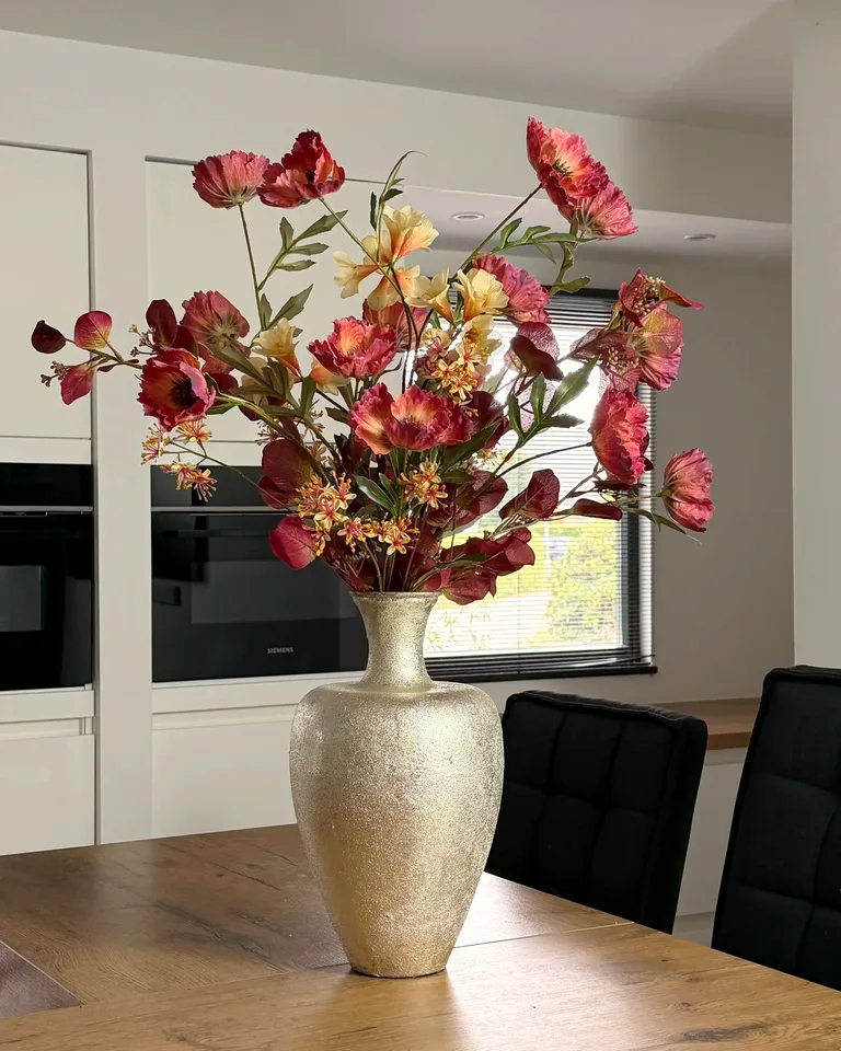 Elodie boeket in mauve en peach in een hoge vaas in het interieur