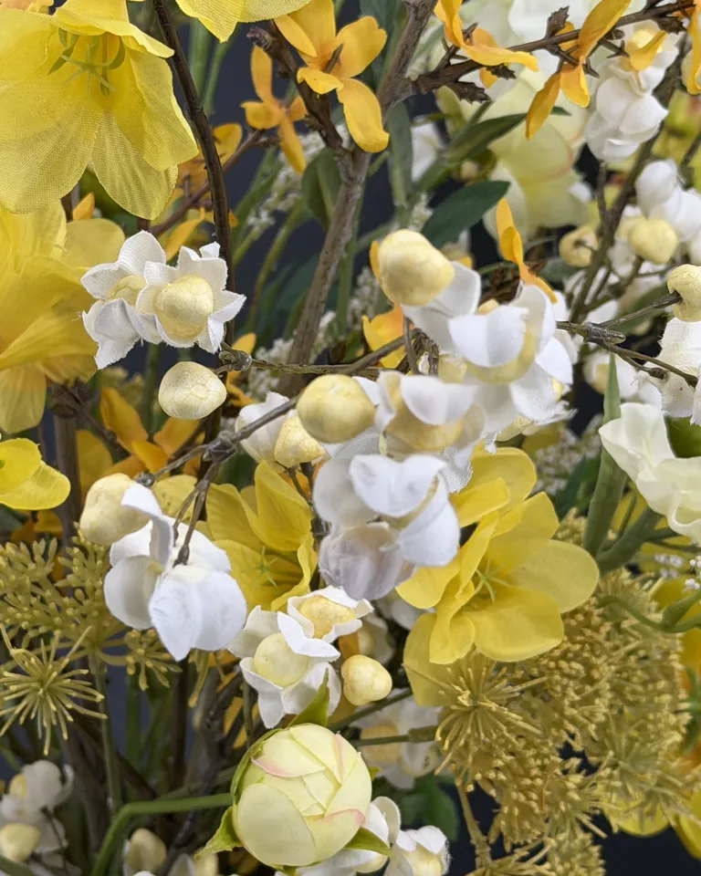 Zelora geel-wit veldboeket in groene vaas, met gele bloemen, witte bloesem en luchtige takken.