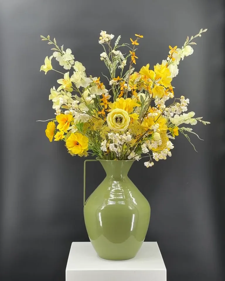 Zelora geel-wit veldboeket in groene vaas, met gele bloemen, witte bloesem en luchtige takken.