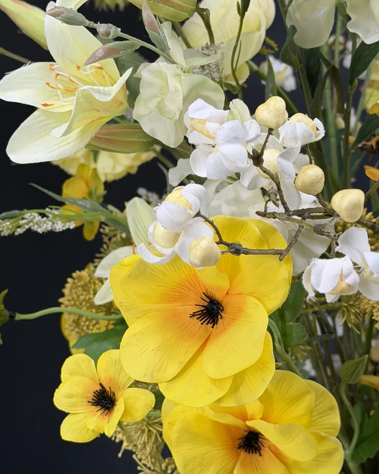 Zelora geel-wit veldboeket in groene vaas, met gele bloemen, witte bloesem en luchtige takken.