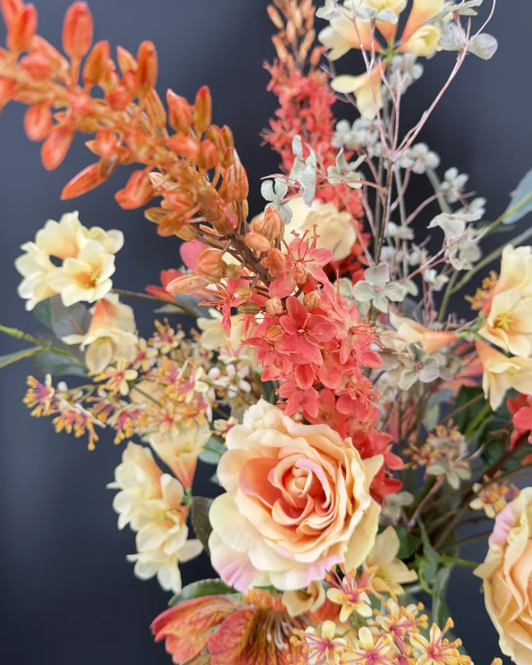 Detail van oranje en rode bloemen, perzikkleurige roos en lichte bloesem van Solara