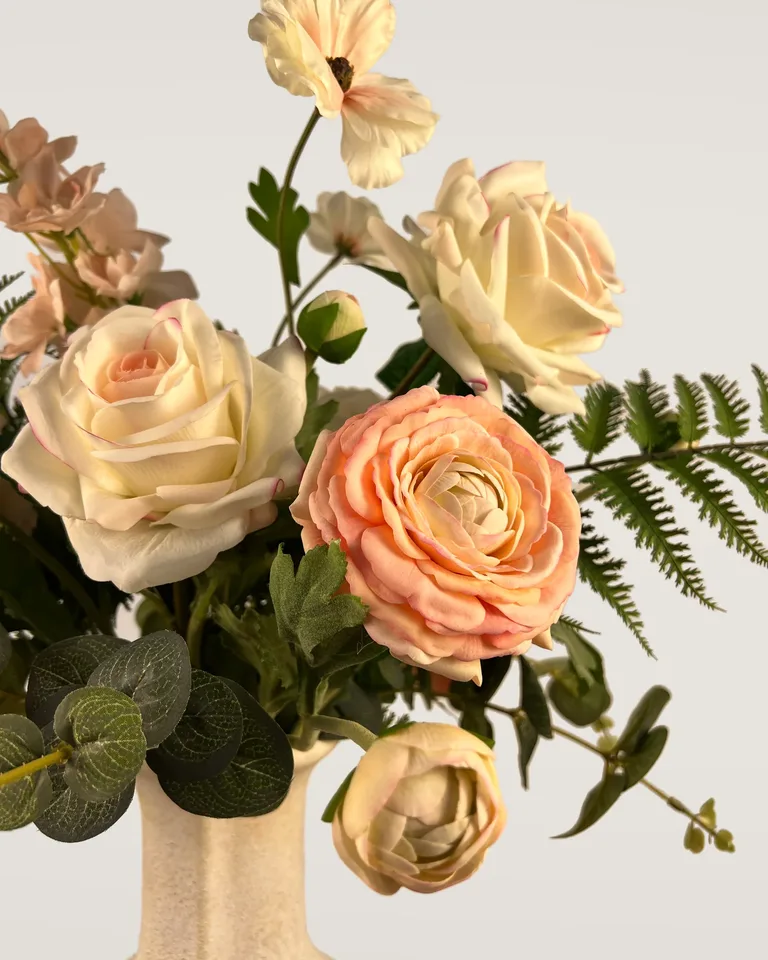 Close-up van Aveline met gelaagde peach bloemblaadjes, lichte rozen en fijn groen.