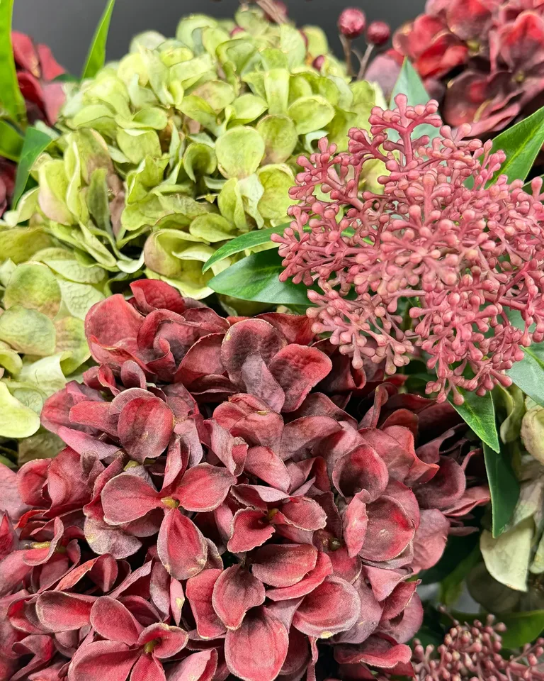 Bordeauxrode en groene hortensia's met skimmia in Oriane.