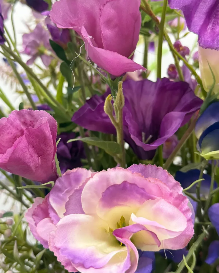 Detail van een zachtroze bloem tussen paarse bloemen in zijden boeket Lilou.