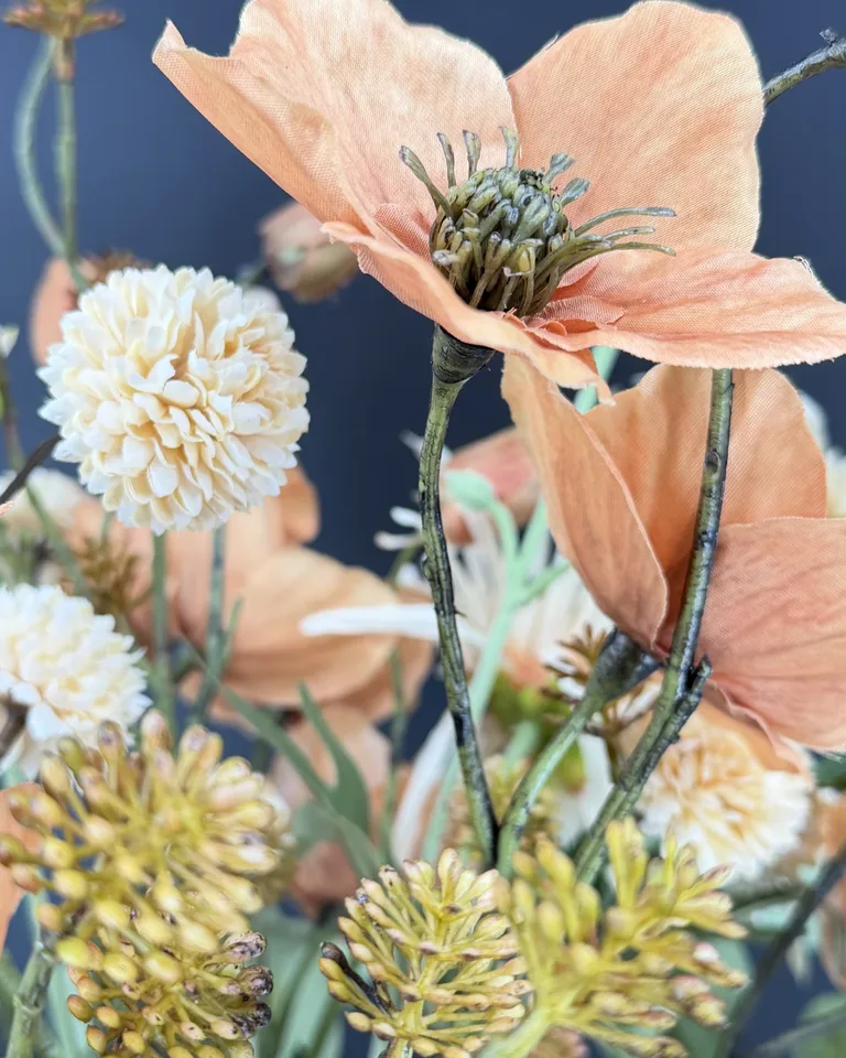 Detail van terracotta bloemen, een crème pomponbloem en roestkleurige takjes in boeket Solenne.