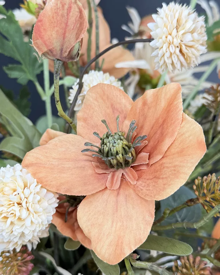 Close-up van een terracotta bloem met crème pomponbloemen in boeket Solenne.