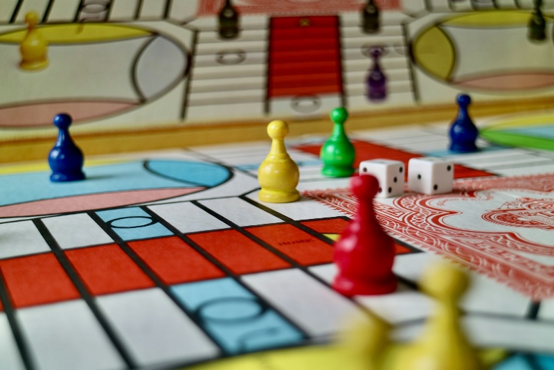 Colorful game pawns and dice arranged on a bright, playful board game