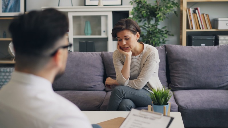 Two people sit in an office discussing therapy matters