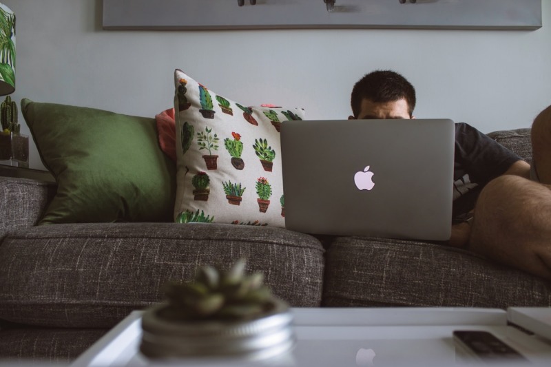 A man sitting on a couch with his computer open during a therapy sesison