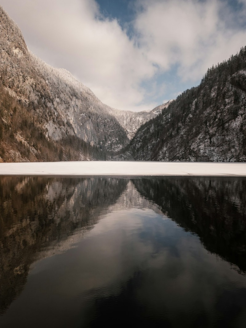 A mountain range mirrored in the still water of a lake
