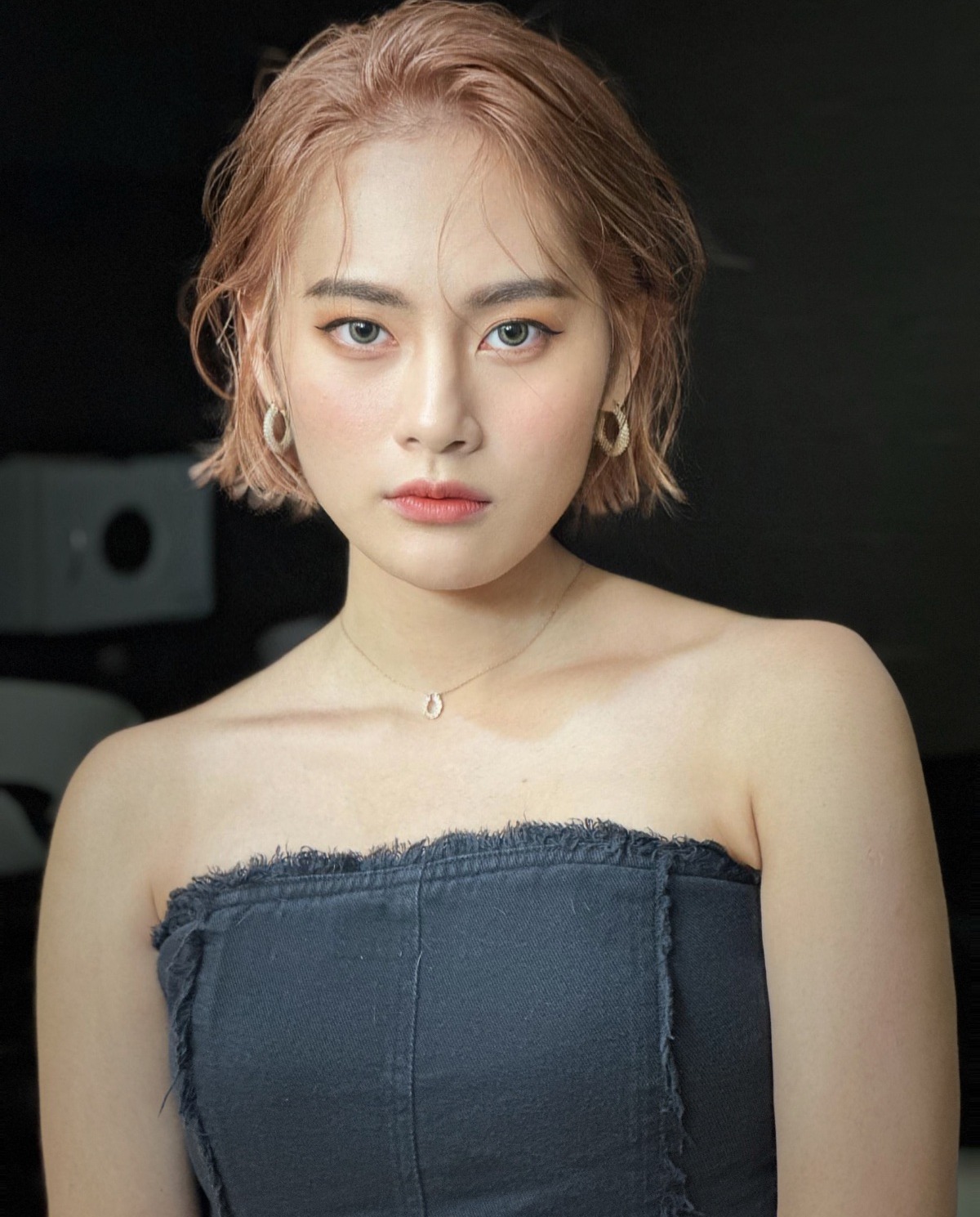 女生短髮外翻上捲：金棕色短髮髮尾往上捲，露出肩線