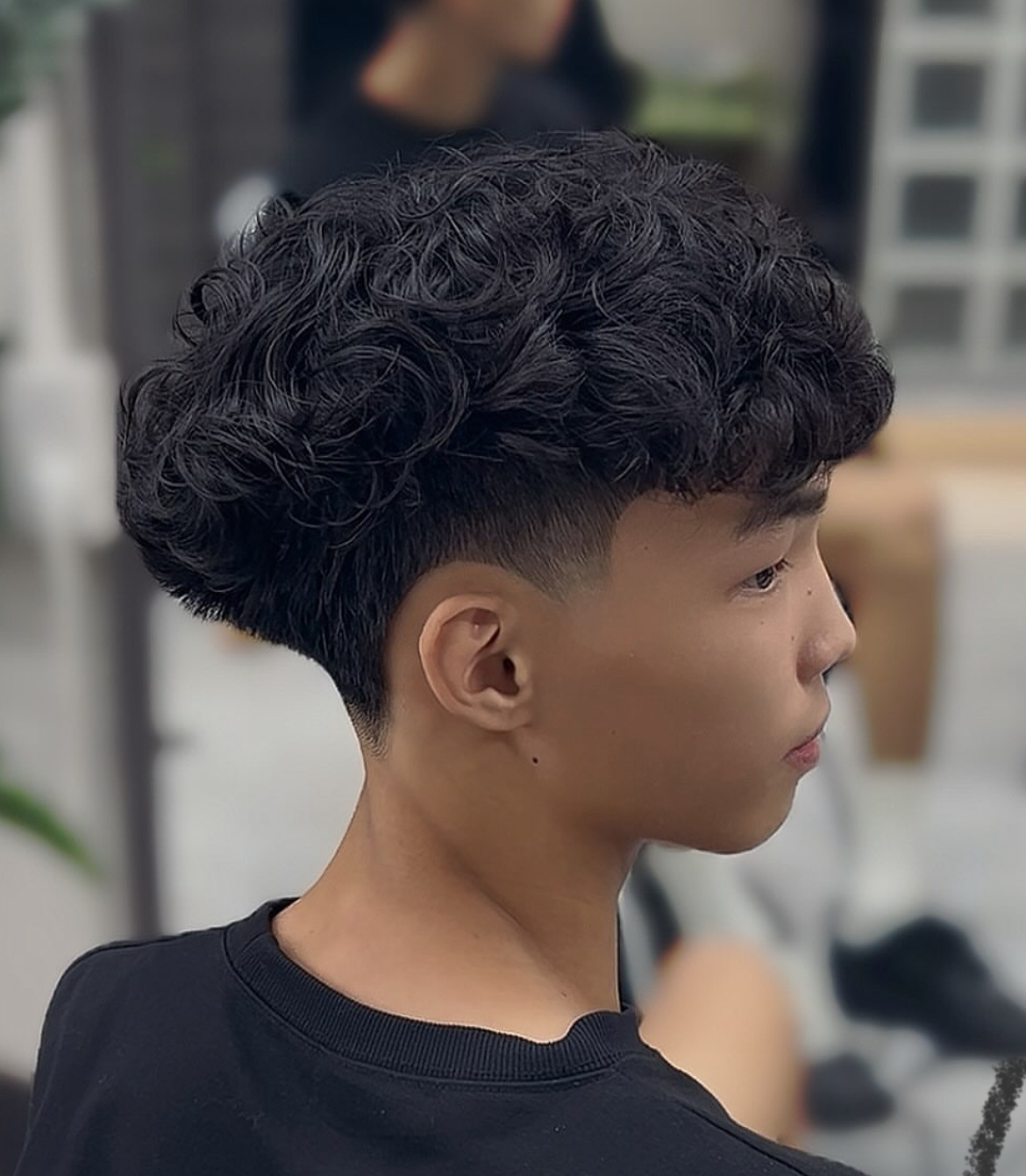 男生羊毛捲側面：濃密黑捲集中在頭頂，兩側推短