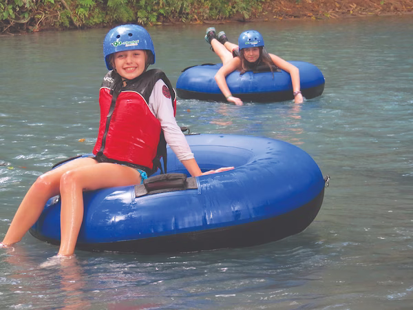 Boy and girl floating on the Arenal River in tubes, enjoying the tubing tour