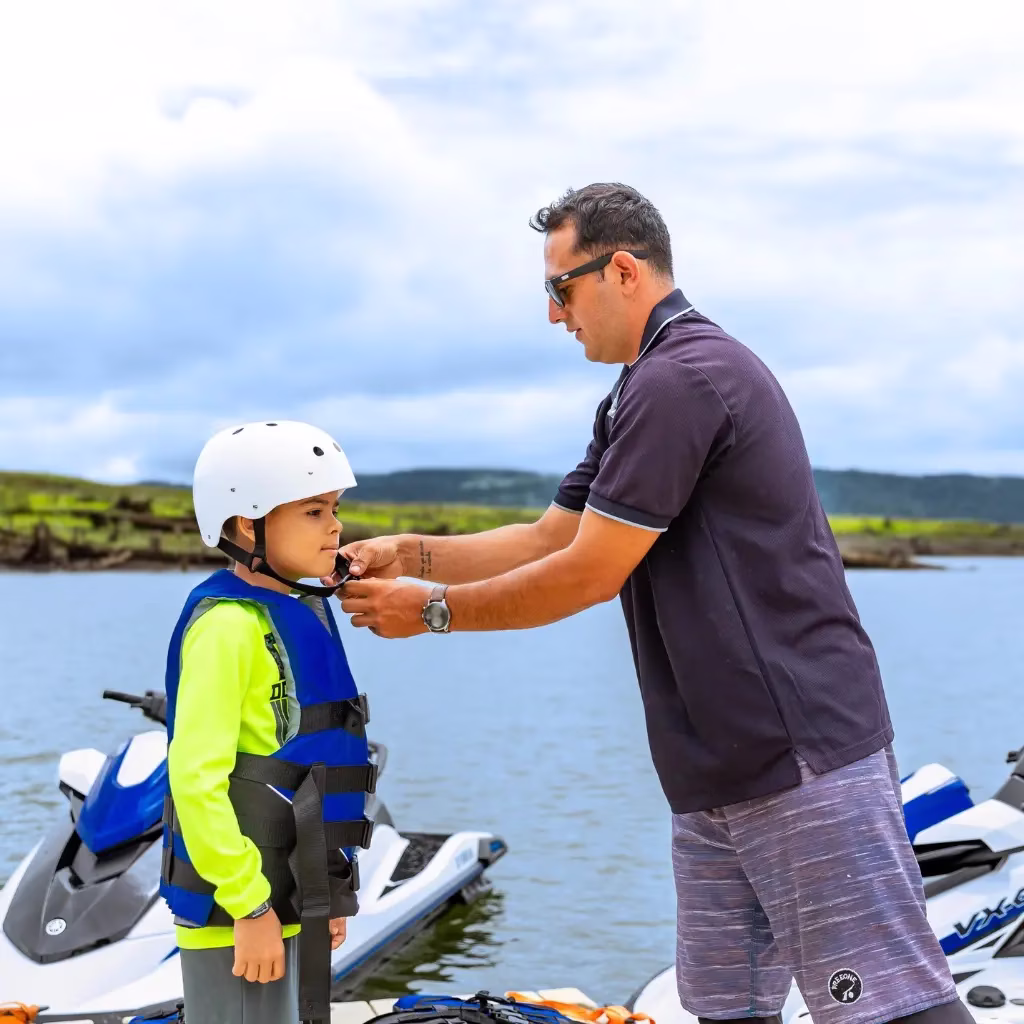 Guide adjusting a child’s helmet at the dock before beginning the jet ski tour on Lake Arenal, Costa Rica