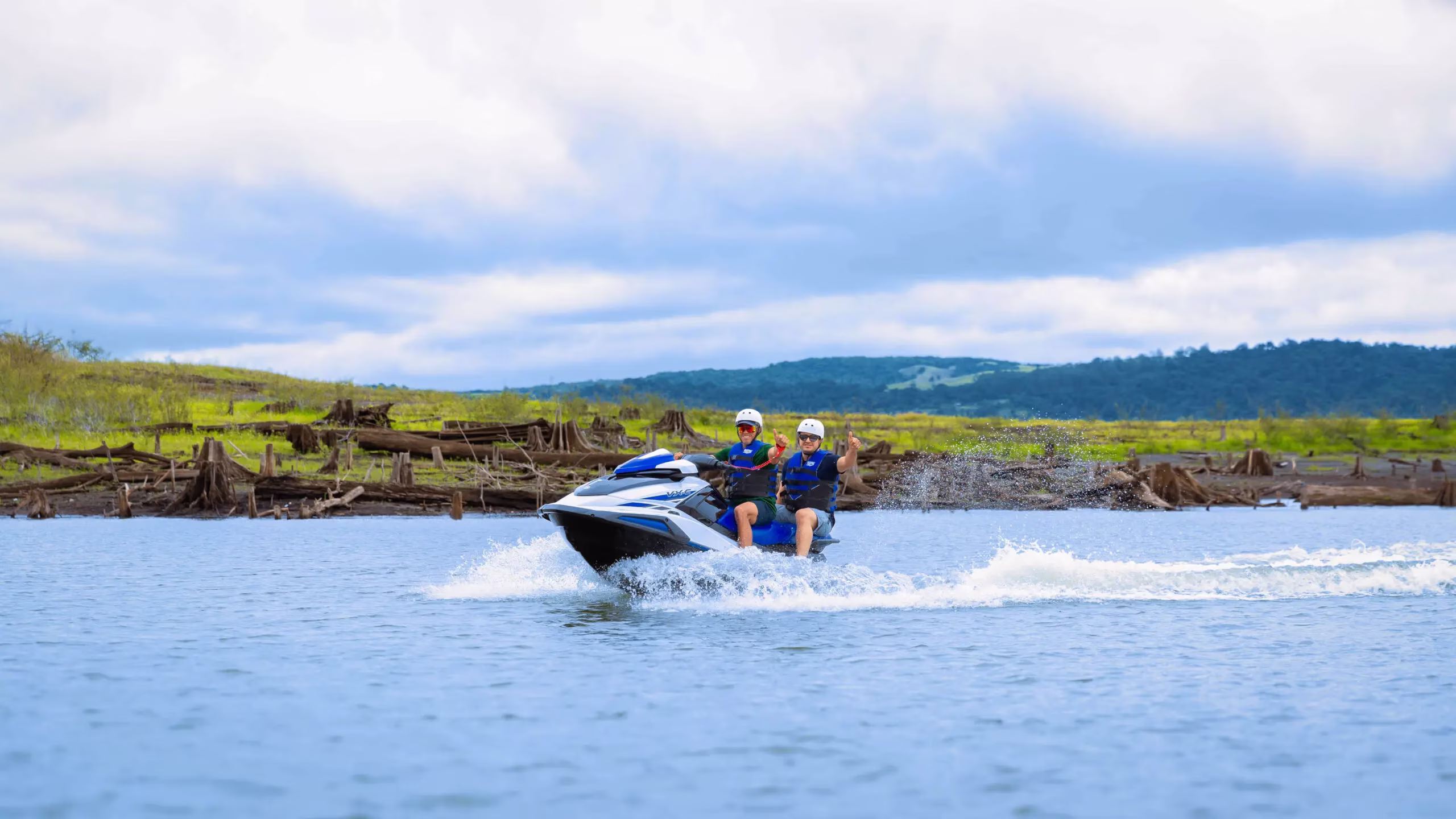 Guests giving thumbs up while riding jet skis on Lake Arenal during the tour, Costa Rica