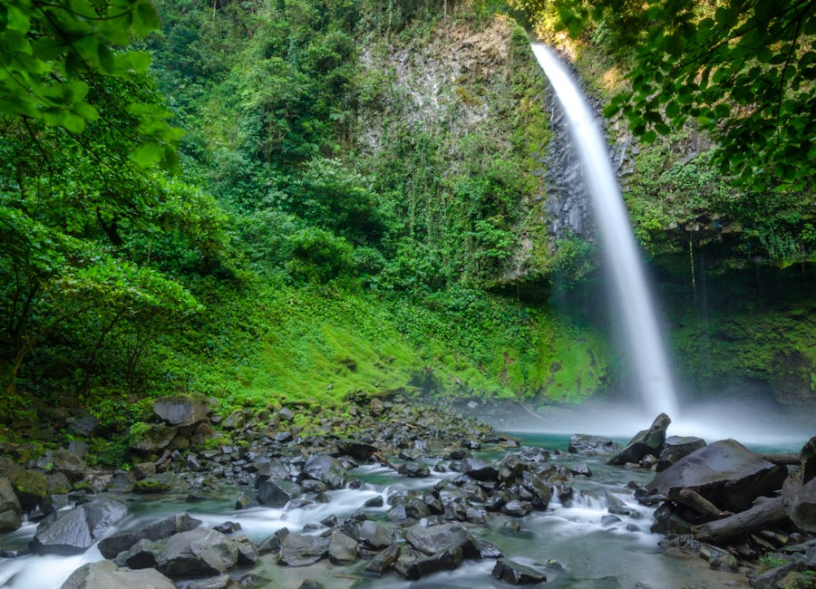 Alternate angle of La Fortuna Waterfall flowing over rocky base in La Fortuna, San Carlos, Costa Rica
