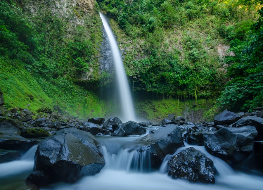 Wide view of La Fortuna Waterfall and rocky river surroundings in La Fortuna, San Carlos, Costa Rica