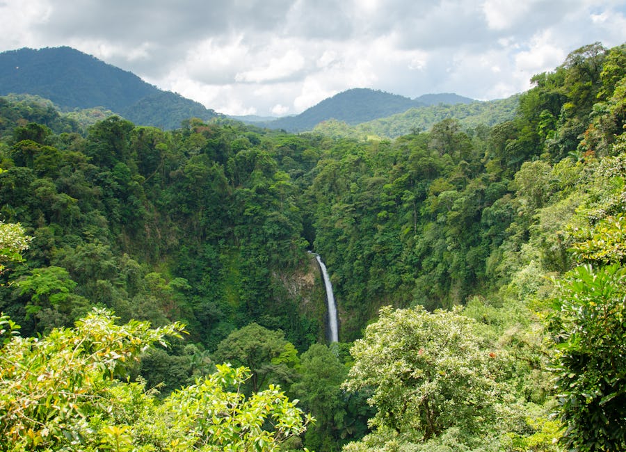 Aerial drone view of La Fortuna Waterfall surrounded by dense tropical forest in San Carlos, Costa Rica