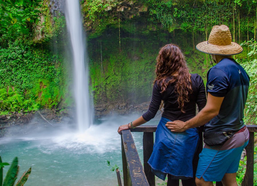 Couple enjoying the waterfall view from a viewpoint at La Fortuna Waterfall, San Carlos, Costa Rica