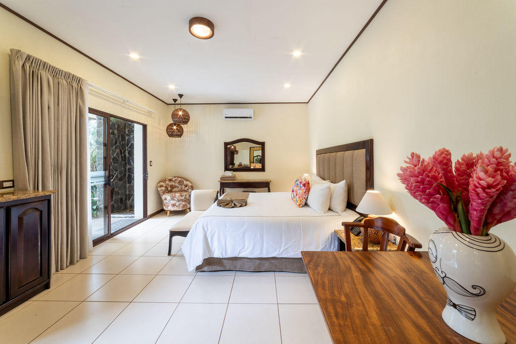 Side front view of Garden Superior room with king bed and exterior window at Hotel & Spa Poco a Poco, Monteverde