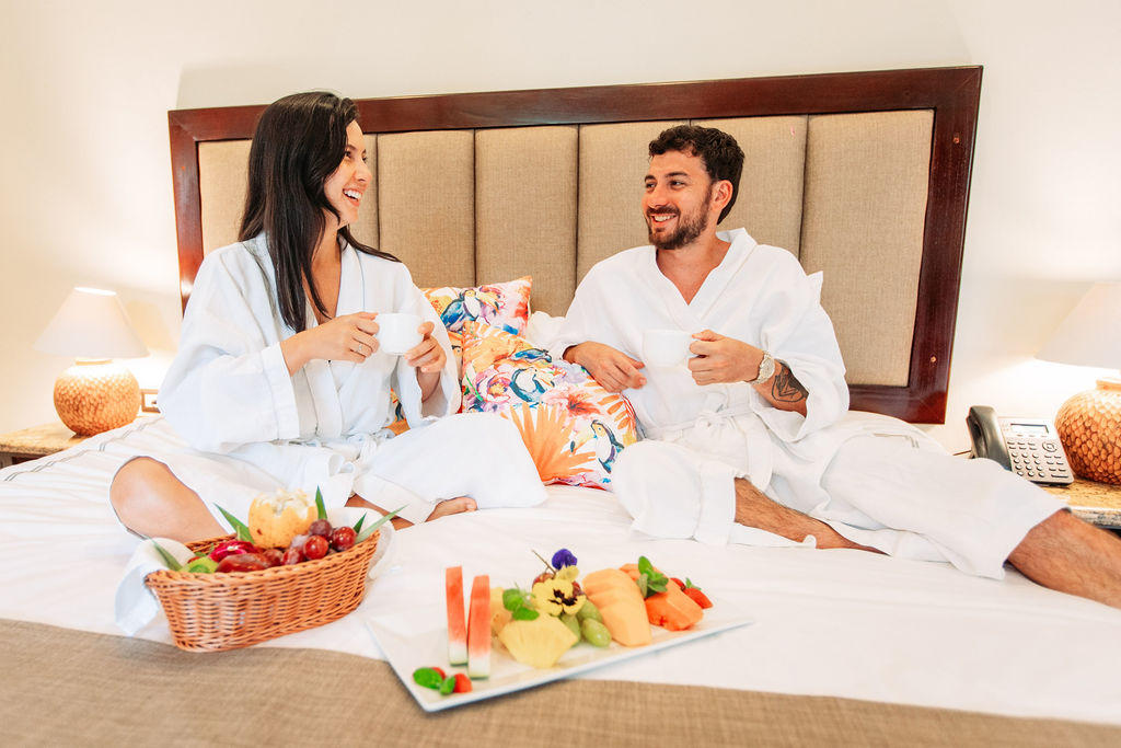 Happy couple wearing robes relaxing on the bed in Forest Deluxe with Jacuzzi at Hotel & Spa Poco a Poco, Monteverde